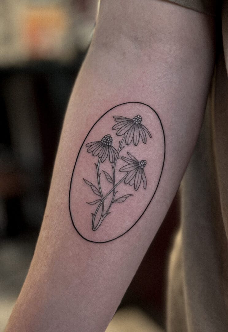 A tattoo of three flowers on the arm.