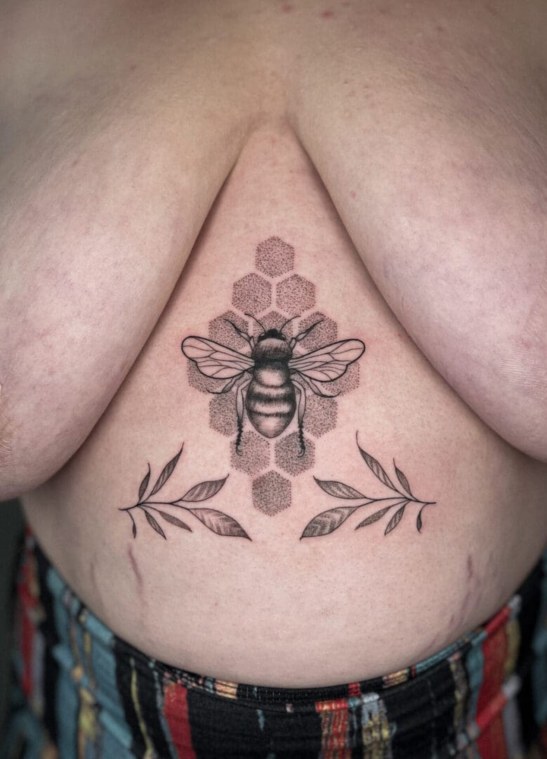 A woman with a bee tattoo on her chest.