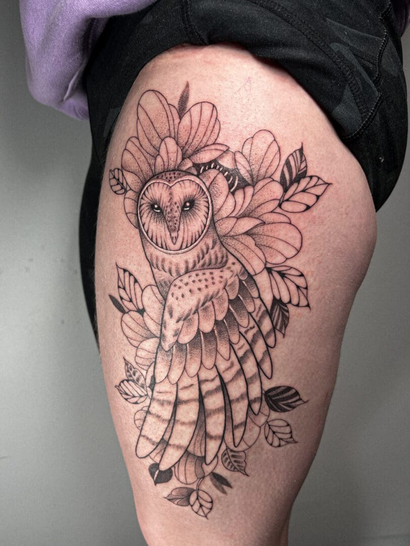 A woman with an owl tattoo on her leg.