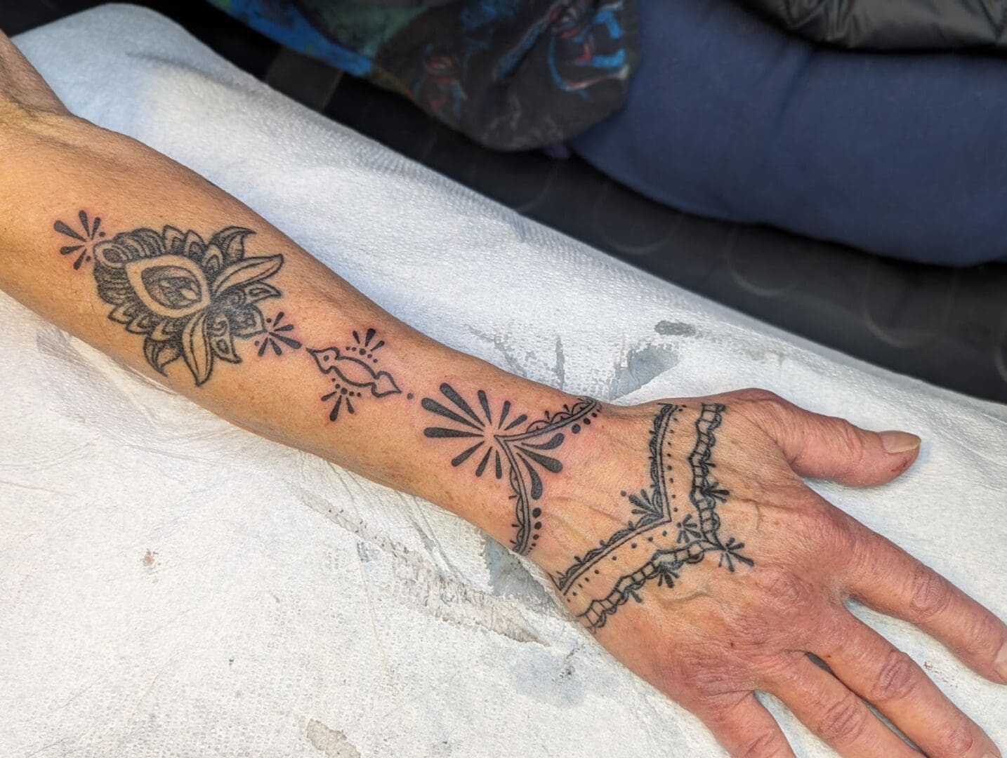 A person with tattoos on their arm and hand.